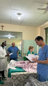 Pasando visita a los pacientes operados junto al equipo médico local