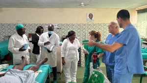 Pasando visita a los pacientes operados junto al equipo médico local