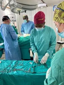 El Dr. Guillermo Pou junto al Dr. Alain y la enfermera Hilda durante una intervención laparoscópica en el Hospital Notre Dame de la Santé, ejemplo de la colaboración entre el equipo local y Surg For All.